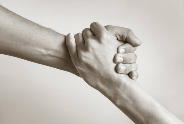Black and white image of a close up of man's and woman's hand helping.